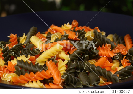 Colorful various raw fusilli on black plate Colorful various raw fusilli on black plate 131200097