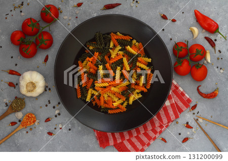 Colorful various raw fusilli on black plate Colorful various raw fusilli on black plate 131200099