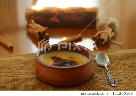 Baked rice pudding turkish dessert sutlac in earthenware casserole with cinnamon sticks 131200109