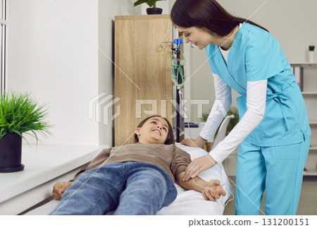 Nurse gives an intravenous medical infusion to a child girl patient in the hospital 131200151
