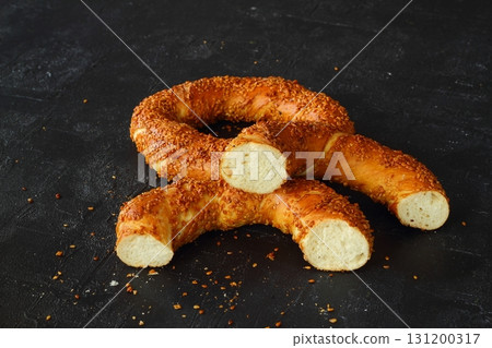 Turkish simit bagel dusted with sesame seeds on a black background. 131200317