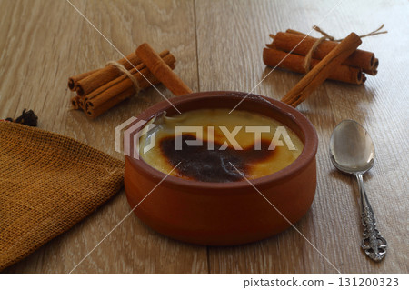 Baked rice pudding turkish dessert sutlac in earthenware casserole with cinnamon sticks Baked rice pudding turkish dessert sutlac in earthenware casserole with cinnamon sticks 131200323
