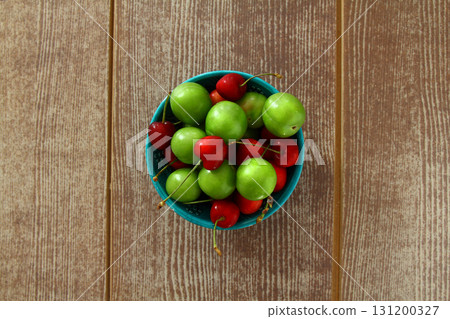 Single whole fresh green Can Erik plum and cherry close up isolated on dark background 131200327
