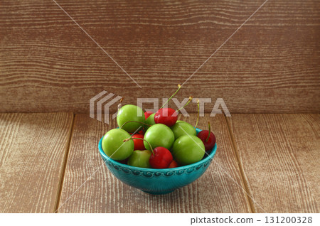 Single whole fresh green Can Erik plum and cherry close up isolated on dark background 131200328