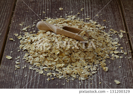 Oat flake in a sack and spoon on the wooden table 131200329