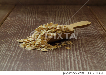 Oat flake in a sack and spoon on the wooden table Oat flake in a sack and spoon on the wooden table 131200331