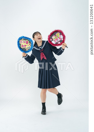 Full-body photo of a female student wearing a sailor uniform holding a fan 131200641