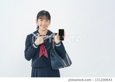 A female student wearing a sailor suit showing her smartphone screen A female student wearing a sailor suit showing her smartphone screen 131200643