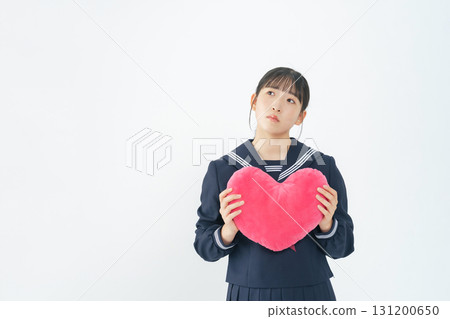 A female student wearing a sailor suit holding a heart A female student wearing a sailor suit holding a heart 131200650