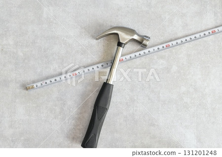 Hammer and stainless steel scale on a gray background 131201248