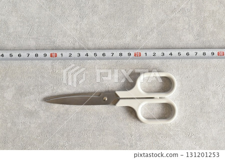 White scissors and stainless steel scale on a gray background 131201253
