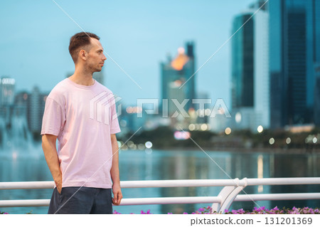 handsome man on vibrant night city with skyscrapers background, stylish guy posing with glowing urban skyline at evening handsome man on vibrant night city with skyscrapers background, stylish guy posing with glowing urban skyline at evening 131201369