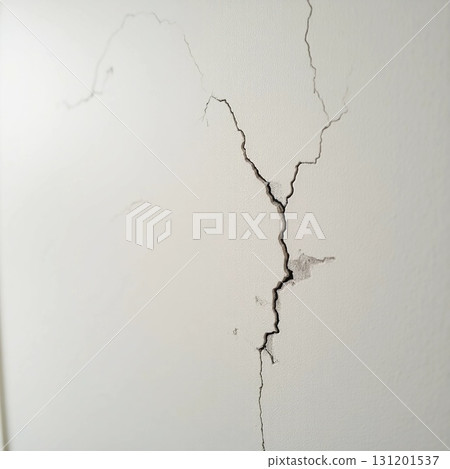 Deep cracks spider across the surface of a textured wall, hinting at years of weathering and neglect in an urban environment, evoking curiosity about past events Generative AI 131201537