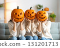 Three people hold carved pumpkins in front of their faces for Halloween fun.. 131201713