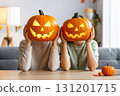 Two people hold carved pumpkins in front of their faces for Halloween fun.. 131201715