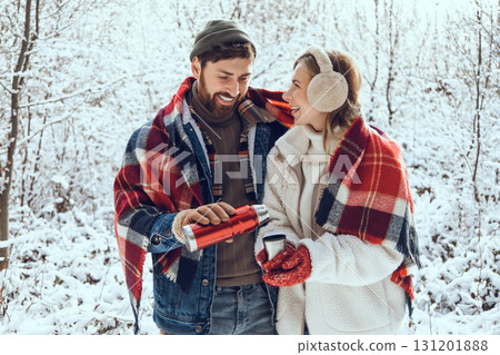 Smiling man pouring hot tea to his girl friend cup and both looking enjoyed Smiling man pouring hot tea to his girl friend cup and both looking enjoyed 131201888