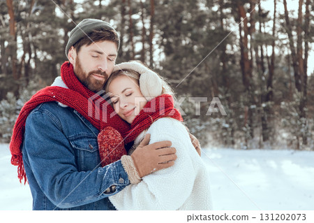 Young dark-haired man hugging his girl friend and both looking happy Young dark-haired man hugging his girl friend and both looking happy 131202073