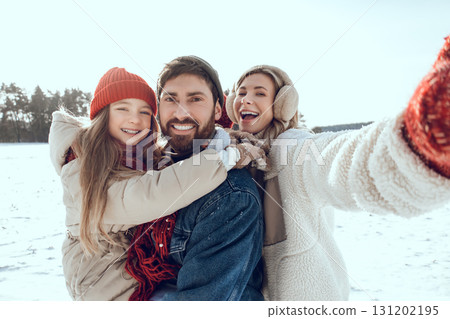 Happy family enjoying snowy weather in the forest and having fun together Happy family enjoying snowy weather in the forest and having fun together 131202195