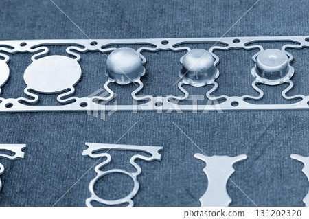 Sample of stamping part of metal drawing process on the progressive die in the light blue scene. Sample of stamping part of metal drawing process on the progressive die in the light blue scene. 131202320