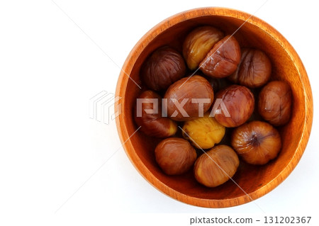 去皮的甜栗子放在白色背景上的木盤子上，從正上方觀看 131202367