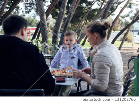 happy family eating pizza in cafe outside, lifestyle people happy family eating pizza in cafe outside, lifestyle people 131202760