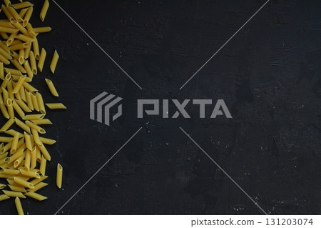 Penne rigate pasta pattern on black background, top view, flat lay texture 131203074