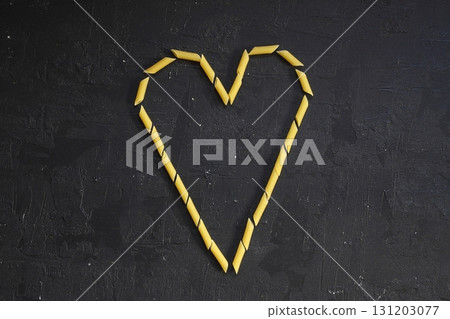 Pasta in the shape of a heart on a black background. Pasta in the shape of a heart on a black background. 131203077