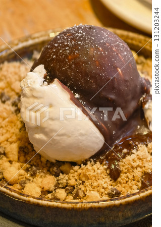 Delightful dessert featuring ice cream and chocolate sauce on crumbled cookies Delightful dessert featuring ice cream and chocolate sauce on crumbled cookies 131203244