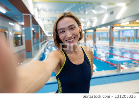 Happy short-haired young woman making selfie at the pool Happy short-haired young woman making selfie at the pool 131203326