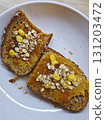 Peanut butter and jam toast with granola on white plate. Whole grain bread toast with peanut butter, fruit jam and granola topping. Simple homemade breakfast served on a white plate. Healthy vegetaria 131203472