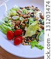 Fresh salad with lettuce, seeds, nuts and cherry tomatoes. Fresh vegetable salad with lettuce, cherry tomatoes, nuts and seeds on a white plate. Includes a small portion of buckwheat for extra texture 131203474