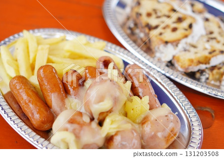 Close-up photo of a hearty Western gourmet meal of sausages and french fries topped with cheese Close-up photo of a hearty Western gourmet meal of sausages and french fries topped with cheese 131203508