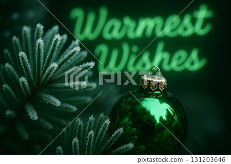 Warmest Wishes text with glowing green bauble and pine leaves on festive dark background. 131203646