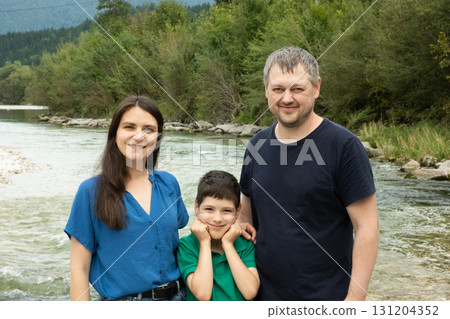 Happy family mom, dad and child walking in nature Happy family mom, dad and child walking in nature 131204352