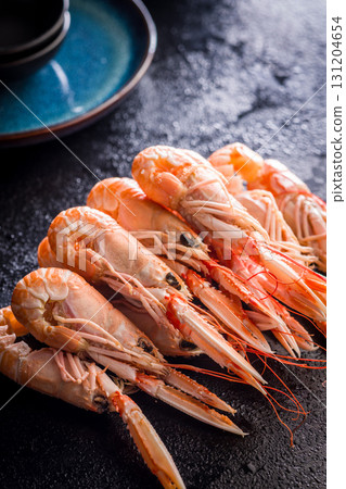 Scampi langoustine on black table. Scampi langoustine on black table. 131204654