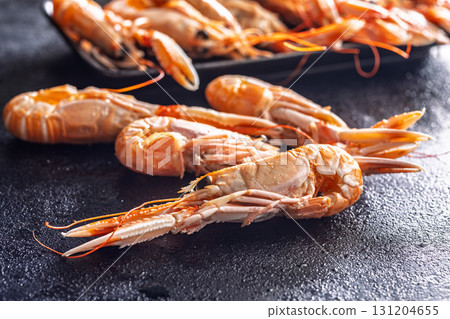 Scampi langoustine on black table. Scampi langoustine on black table. 131204655
