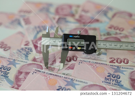 Turkish Lira banknotes of various color, pattern and value on white background With caliper. Selective focus. 131204672