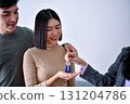 A young couple receives keys from a professional during a property handover. 131204786