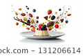 A decorative pudding sits on a white plate, surrounded by various floating ingredients like berries, nuts, and chocolate. This artistic display highlights delicious elements. 131206614