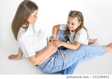 A girl with a pregnant mother on a white studio background. Waiting for the birth of the second baby. Healthy pregnancy. Replenishment in the family A girl with a pregnant mother on a white studio background. Waiting for the birth of the second baby. Healthy pregnancy. Replenishment in the family 131206852