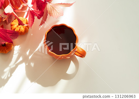 Cozy Autumn Living Room Scene with Mug, Notebook and Seasonal Decor under Sun Light 131206963