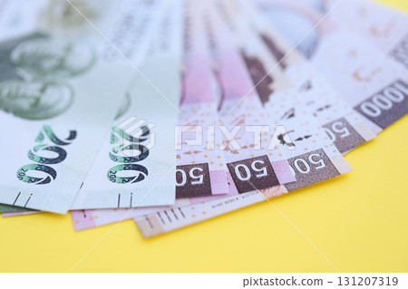 Mexican pesos money bills in big amount lies on yellow color table close up. Finance and banking concept 131207319