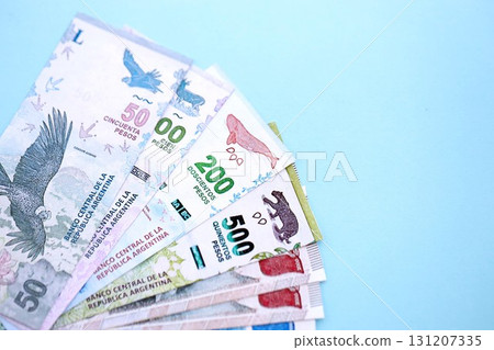 Argentine pesos money bills in big amount lies on teal color table close up. Finance and banking concept 131207335