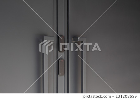 Close up of modern black doors with smart access control system, featuring minimalistic design and security technology, emphasizing convenience and sophistication in urban spaces 131208659