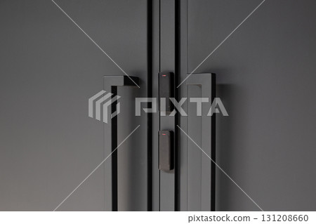 Modern black doors equipped with security panel that requires card swipe for access, offering enhanced safety and privacy control in corporate or residential buildings 131208660
