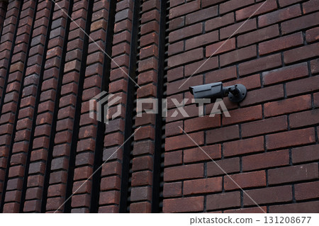 Close up of CCTV camera mounted on brick wall, symbolizing surveillance and security measures. The detailed texture of brickwork emphasizes the urban setting for security purposes 131208677