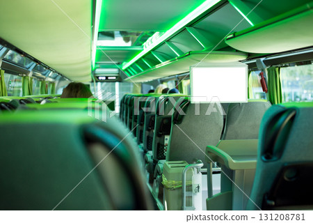 Row of comfortable seats inside a modern tourist bus with green backlight and big white screen with copy space Row of comfortable seats inside a modern tourist bus with green backlight and big white screen with copy space 131208781