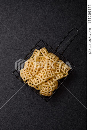 Lattice or wafer potato chips, crispy yellow snacks, takeaway food Lattice or wafer potato chips, crispy yellow snacks, takeaway food 131209123