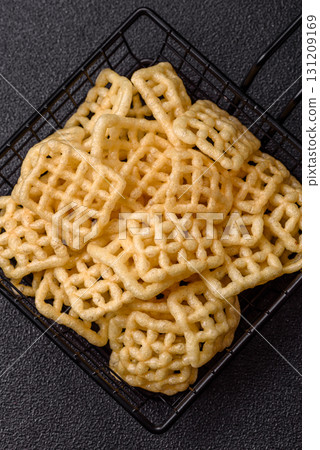 Lattice or wafer potato chips, crispy yellow snacks, takeaway food Lattice or wafer potato chips, crispy yellow snacks, takeaway food 131209169