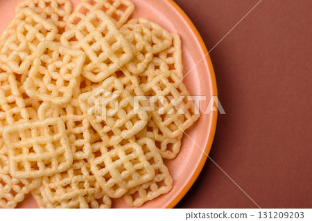 Lattice or wafer potato chips, crispy yellow snacks, takeaway food Lattice or wafer potato chips, crispy yellow snacks, takeaway food 131209203